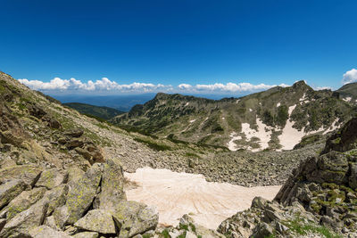 Scenic view of mountains against blue sky