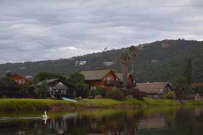 Houses by lake against sky