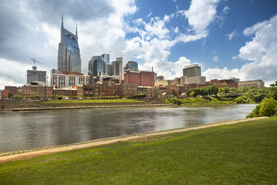 River by buildings against sky in city