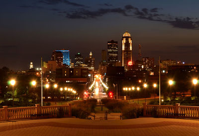 Illuminated buildings in city against sky at night