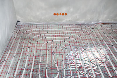 White pipes of underfloor heating systems, distributed in an individual family house on  foil.