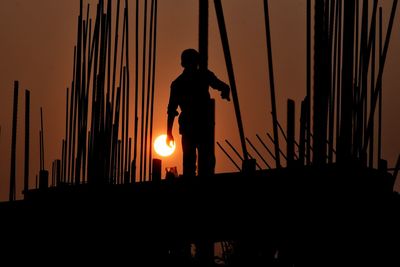 Silhouette man standing against sky during sunset