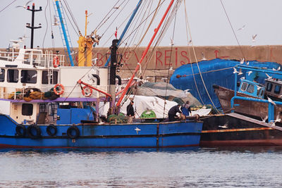 Boats moored at harbor against clear sky