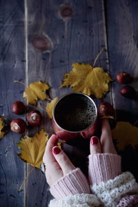 High angle view of woman holding tea cup on table