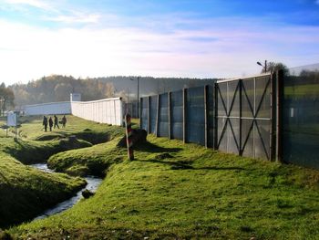 View of grassy field against cloudy sky