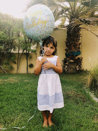 Full length of cute girl standing on grass