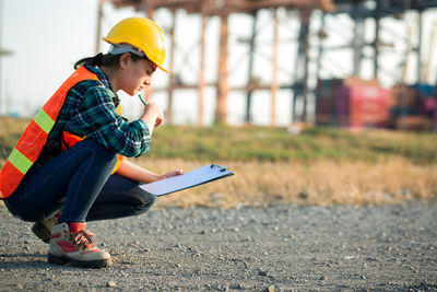 Side view of boy sitting outdoors