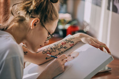 Side view of woman using digital tablet at home