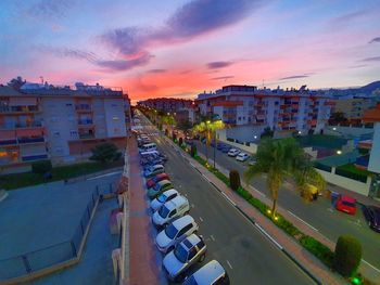 High angle view of street amidst buildings against sky during sunset