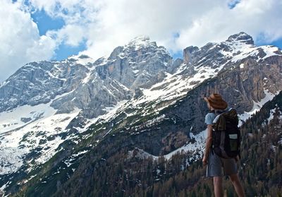 Backpacker looking at snowcapped mountains