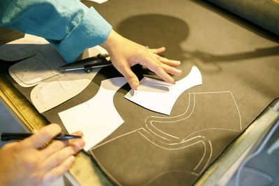 Cropped image of shoemaker working on table in workshop