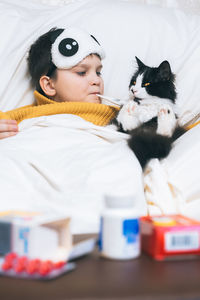 Portrait of woman with cat on bed