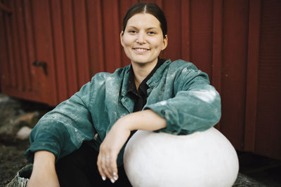 Portrait of smiling woman with ceramic vase