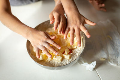 Upper view of childdren's hands putting butter in the bowl