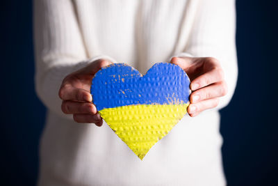 Midsection of woman holding heart shape