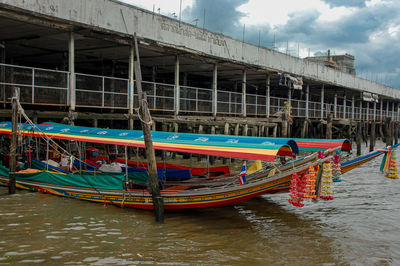 Boats moored in river against buildings