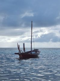 Sailboat in sea against sky