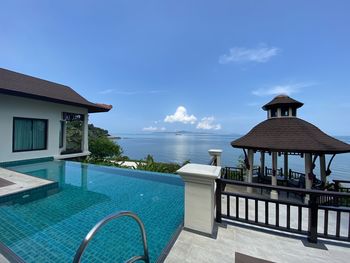 View of swimming pool by building against sky