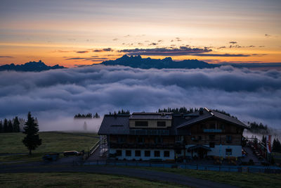 Houses and buildings against sky at sunset