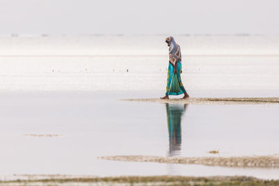 Rear view of woman standing on beach