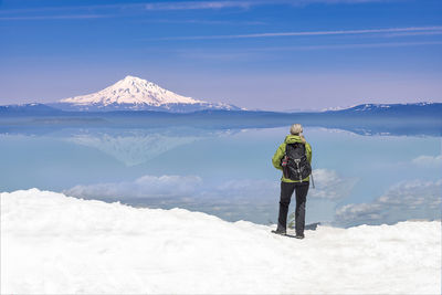 Rear view of woman standing on snow covered landscape