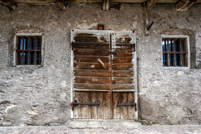 Old weather-damaged wooden door in san martino di castrozza trento italy