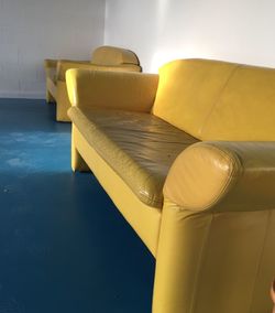Empty yellow sofa by wall on floor