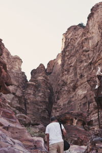 Low angle view of woman standing on rocky mountain