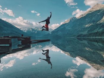 Rear view of man jumping in lake