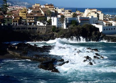 Scenic view of sea against buildings in city