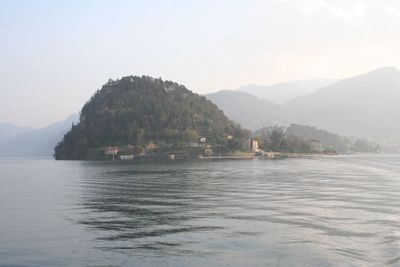 Scenic view of sea and mountains against clear sky