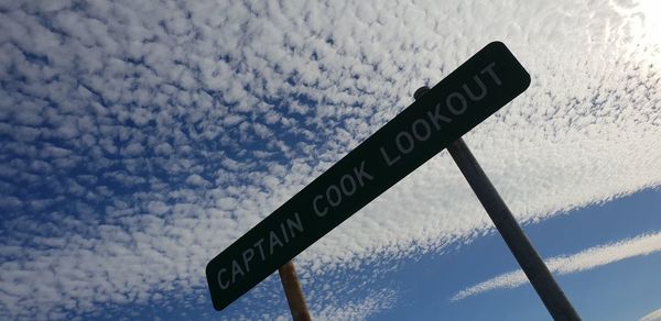 Low angle view of road sign against sky