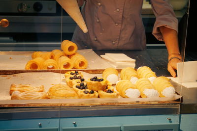 Midsection of chef preparing pastry in kitchen