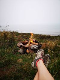 Low section of man relaxing on field