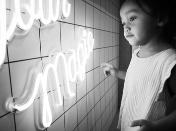 Side view of girl looking at illuminated lamp