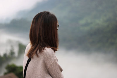 Rear view of woman standing against sky