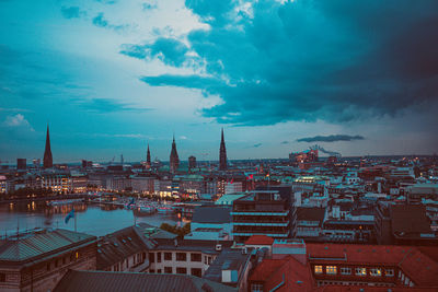 High angle view of buildings in city against cloudy sky during sunset