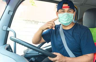 Portrait of young man sitting in car