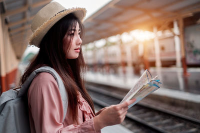 Side view of young woman wearing hat