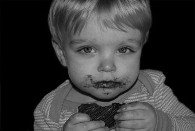 Portrait of cute baby boy eating chocolate