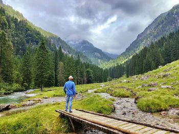 Rear view of man walking on railroad track