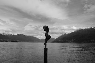 Man looking at lake against mountain range