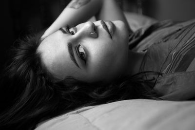 Close-up of young woman lying on bed at home