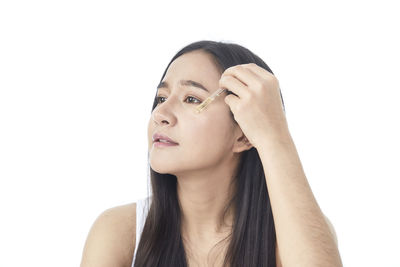 Close-up portrait of a young woman over white background