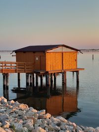 Pier on lake against clear sky during sunset