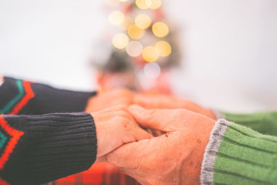 Senior couple in warm clothing holding each others hands at home. loving old romantic couple