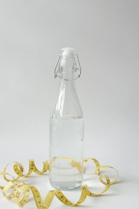 Close-up of glass bottle on table against white background