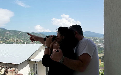 Couple kissing on mountain against sky