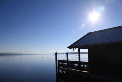 Built structure on sea against blue sky during sunny day