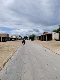 Car on road against cloudy sky